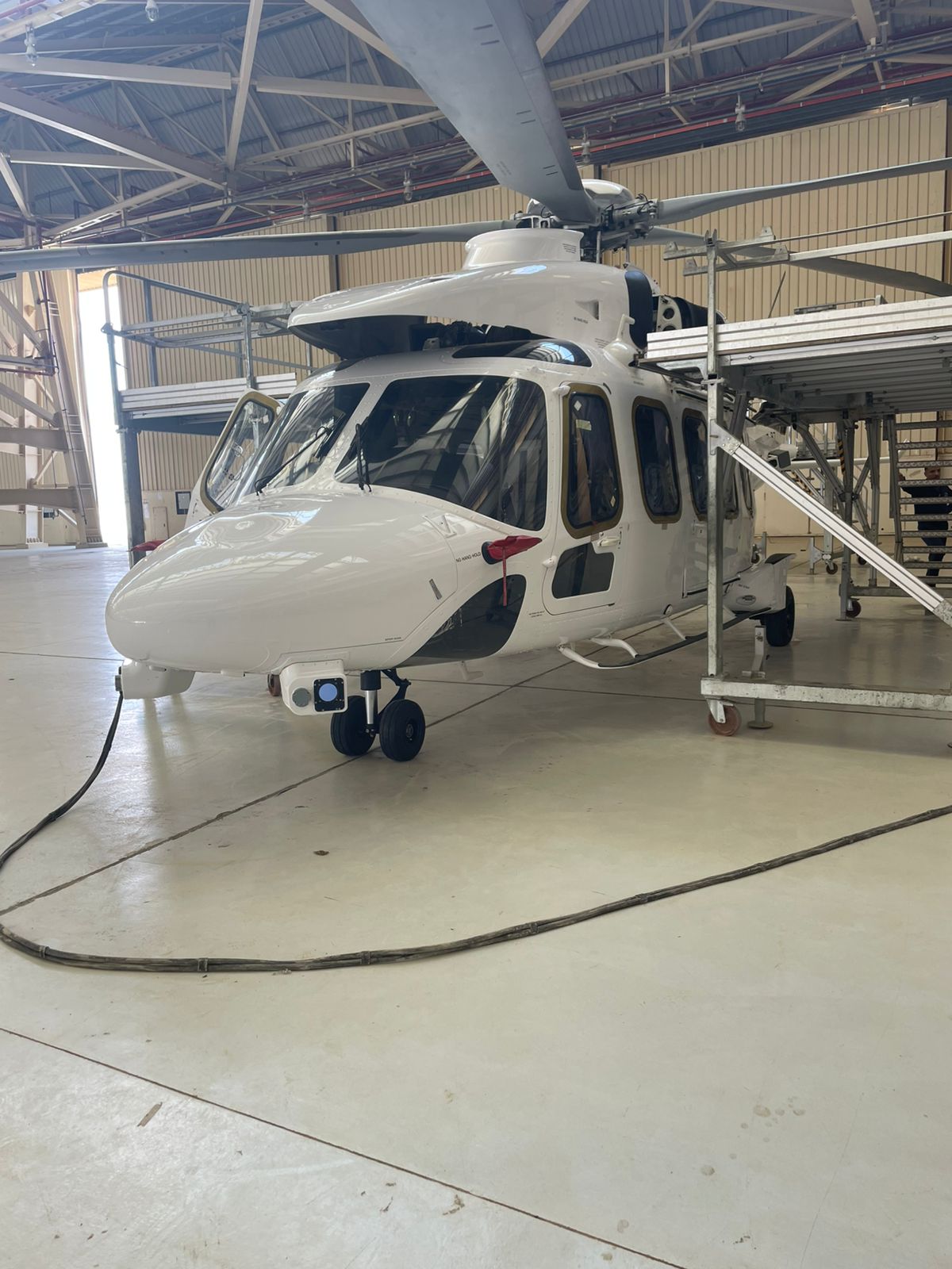 Helicopter on hangar floor with work platforms
